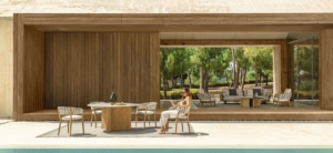 A combination of outdoor and indoor furnishings. Wooden furniture and white fabric.