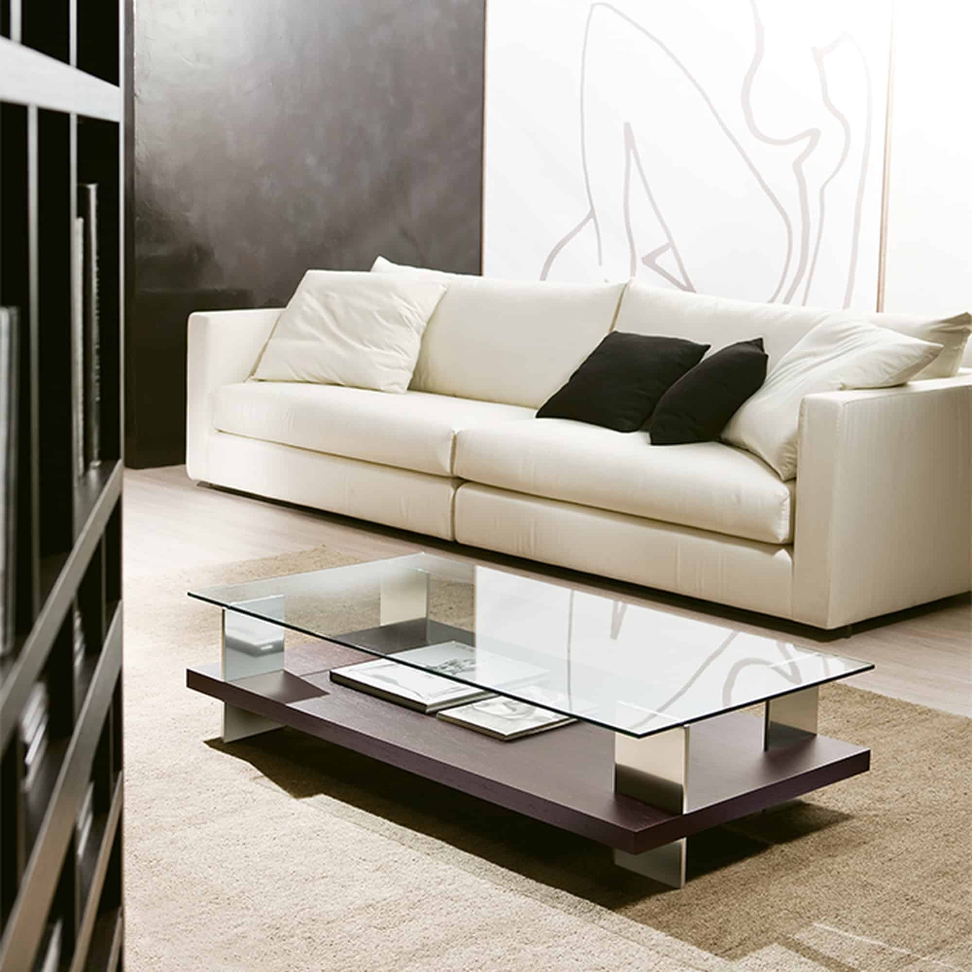 Rectangular Jupiter coffee table in frassino with a wengé finish, clear glass and polished aluminium uprights, in front of a pale sofa.
