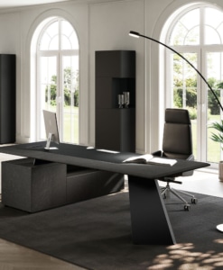Angled view of the black MONOLITH desk with supporting side storage and a V-shaped metal leg.