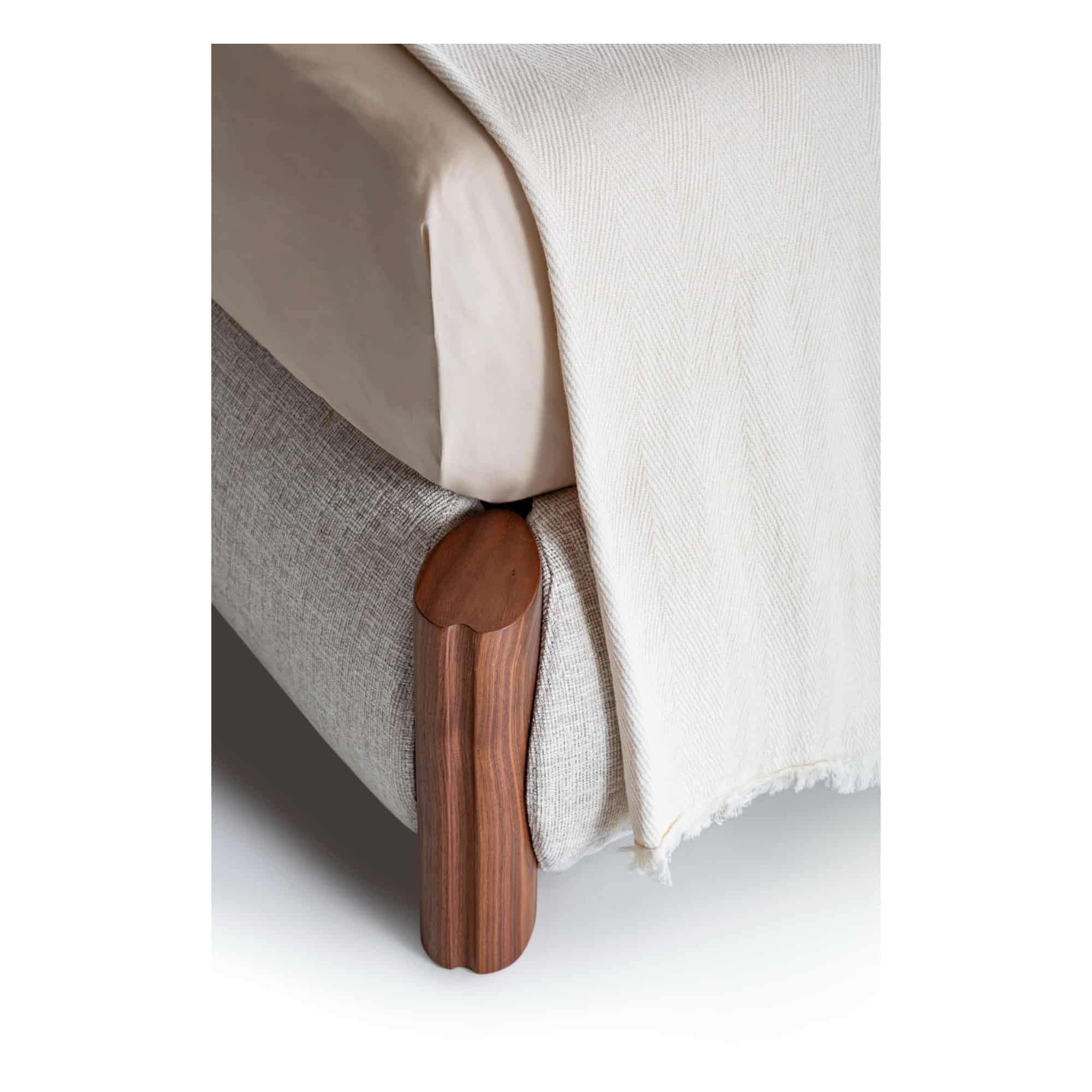 Solid wood foot and fabric upholstery of the Nuage bed